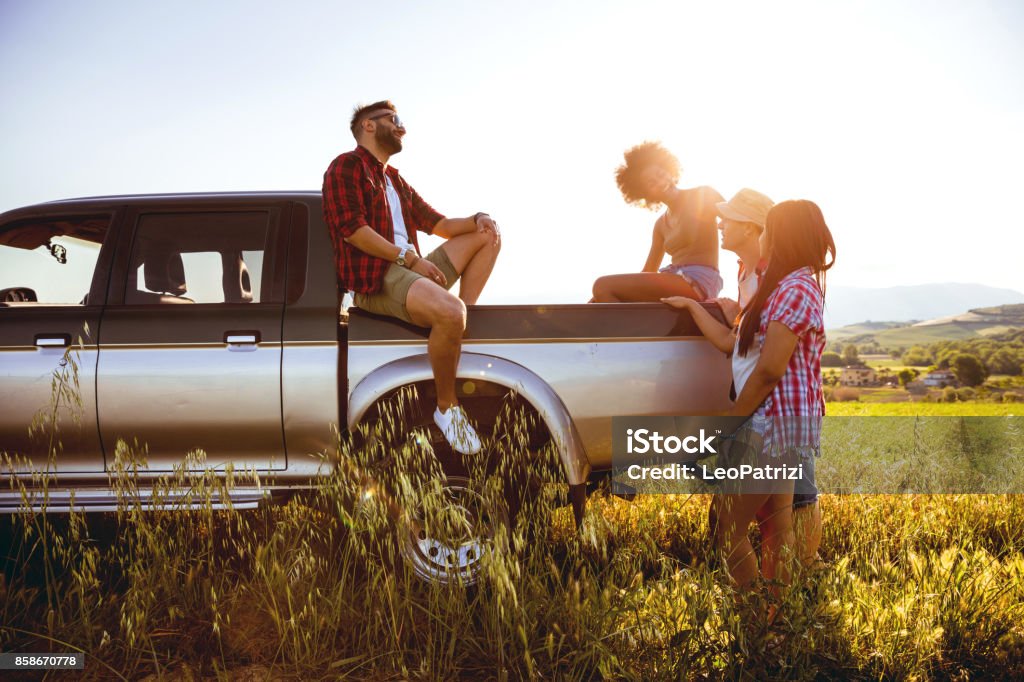 Enjoy the best from our on the road experiences Young friends enjoying the freedom on a Car Trip over a country offroad Pick-up Truck Stock Photo