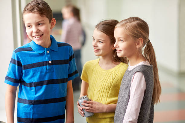 istock group of smiling school kids talking in corridor 858671682