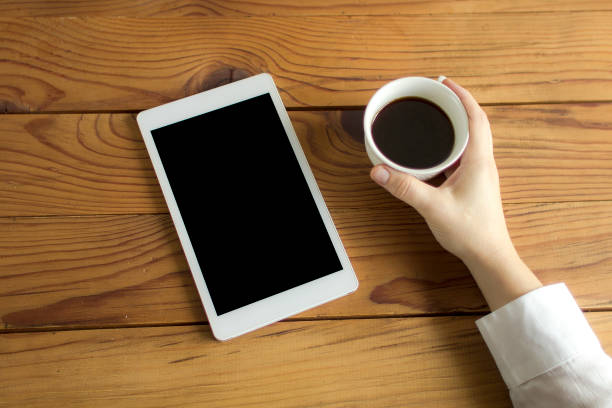 istock Top view of a tablet on a white wooden table 858671776