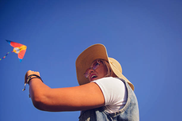 istock Woman in nature flying kite 858675140