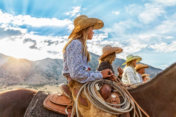 cowgirls e cowboy si allineano in attesa di fare un giro al mattino - cowgirl foto e immagini stock