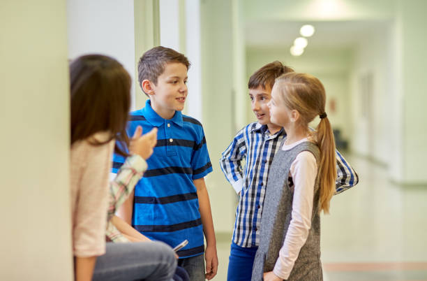 istock group of smiling school kids talking in corridor 858675752