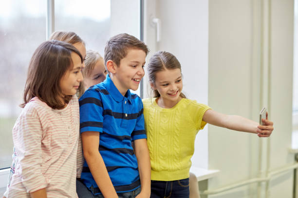 istock group of school kids taking selfie with smartphone 858678106