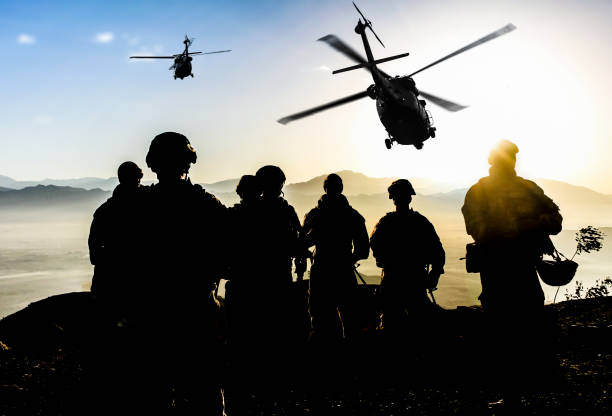 siluetas de soldados durante una misión militar al atardecer - military armed forces us military army fotografías e imágenes de stock