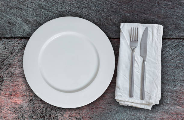 istock Empty plate and cutlery on mahogany wood. 858695194