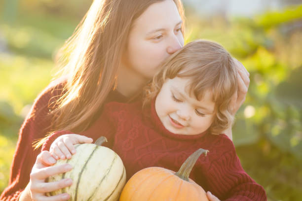 istock Mother and child choosing pumpkins for jack-o-lantern. 858702428
