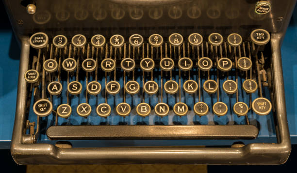 Qwerty keys on ancient mechanical typewriter on blue desk surface
