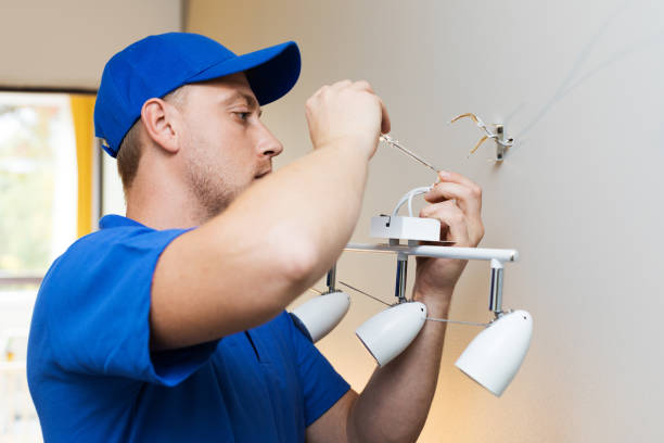 istock electrician at work - installing lamp on the wall 858705890