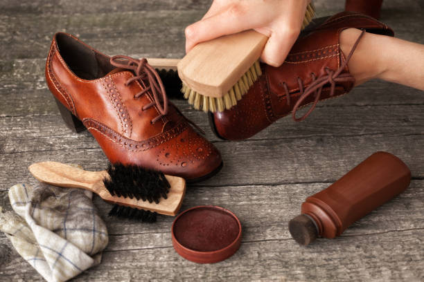 istock Craftsman holding and cleaning shoe with brush 858710664