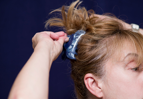 Studio shot of a woman arranging her hair with a hair clip