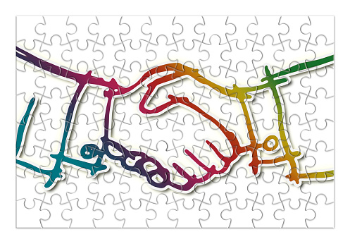 Handshake against a white background - concept image in jigsaw puzzle shape