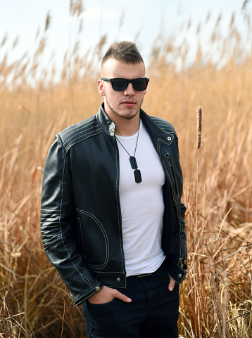 Young man in leather jacket wearing sunglasses outdoor