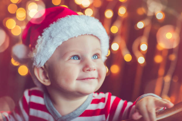 Happy baby boy in bed with xmas lights