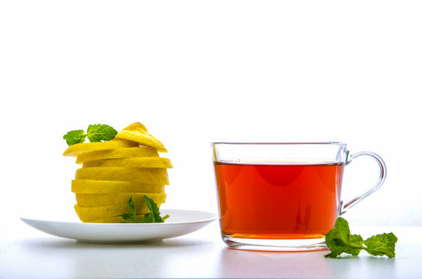 glass cup with tea, mint and a cut lemon on a white background glass cup with tea, mint and a cut lemon on a white background кружка stock pictures, royalty-free photos & images