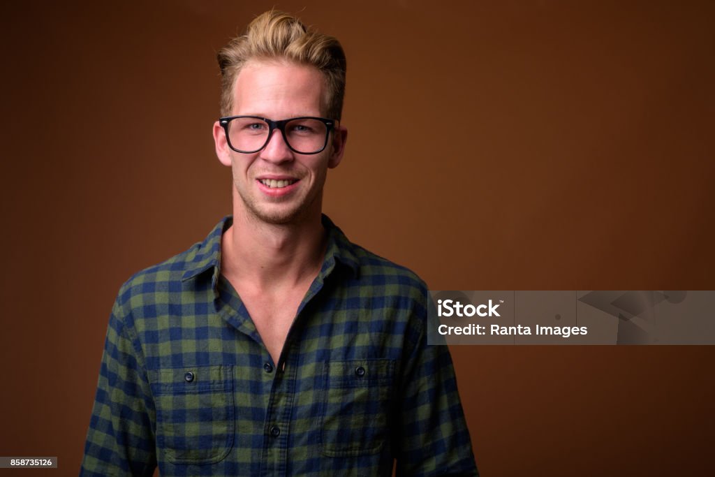 Studio shot of young handsome man wearing smart casual clothing against colored background Studio shot of young handsome man wearing smart casual clothing against colored background horizontal shot 20-24 Years Stock Photo