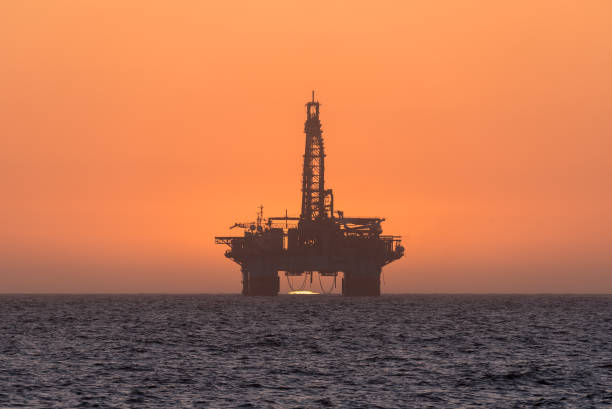 istock Sun setting behind oil drilling platform at Longbeach in Namibia 858737686