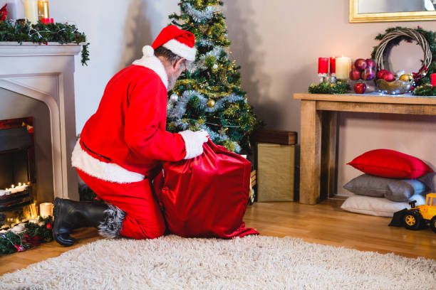 istock Santa Claus putting presents in christmas bag 858737722