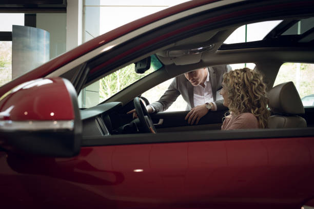 istock Salesman assisting female customer sitting in car 858747748