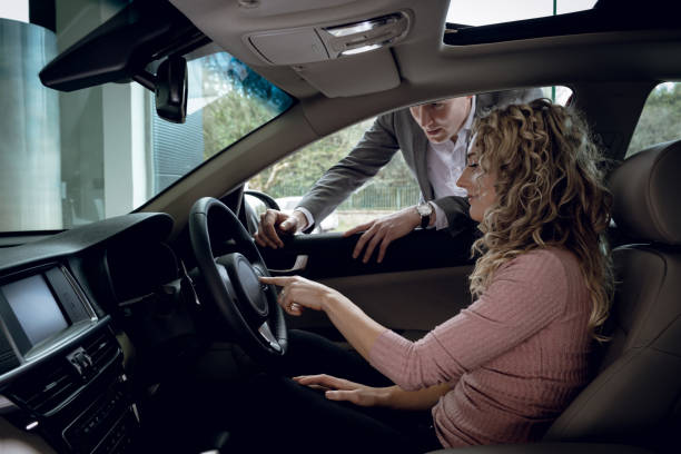 istock Salesman explaining to customer sitting in car 858747784