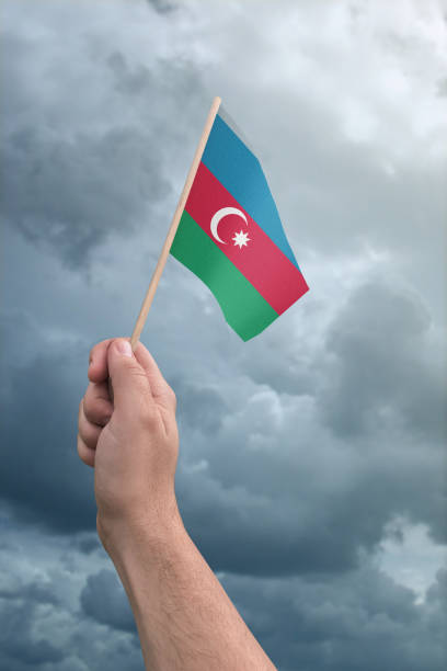 istock Azerbaijan flag held by a hand in front of a cloudy stormy sky 858748274