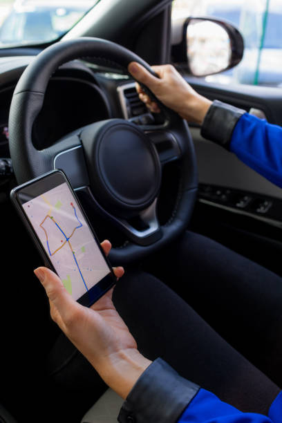 istock Close up of female customer using phone during test drive 858752188