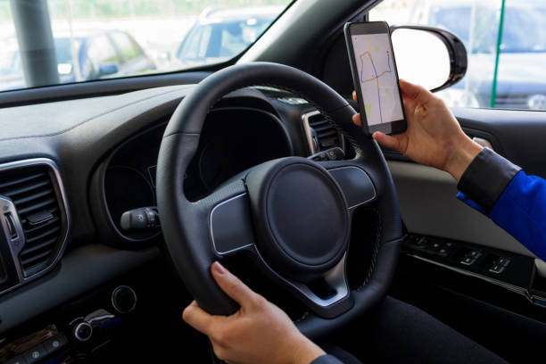 istock Cropped image of woman using phone during test drive 858752244