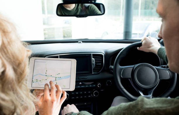 istock Woman showing tablet computer to man during test drive 858752738