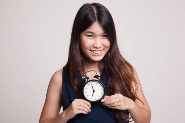 istock Young Asian woman smile with a clock. 858756006