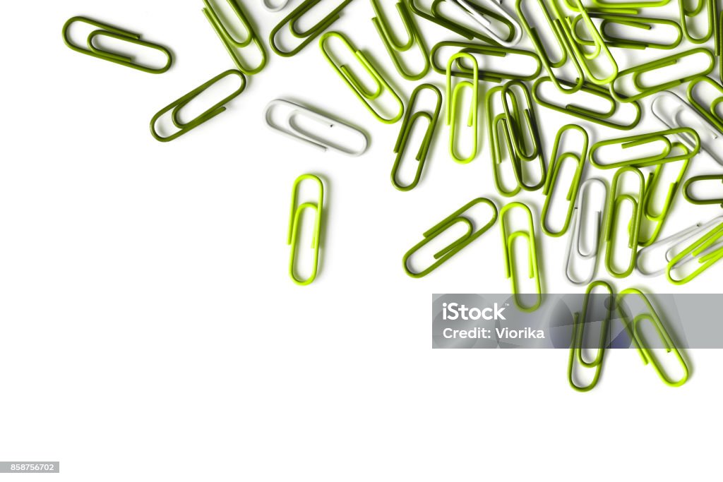 Green paper clips on a white background (50 megapixels) Close-up of green paper clips isolated on a white background. High resolution - 50 megapixels. Space for copy. Paper Clip Stock Photo