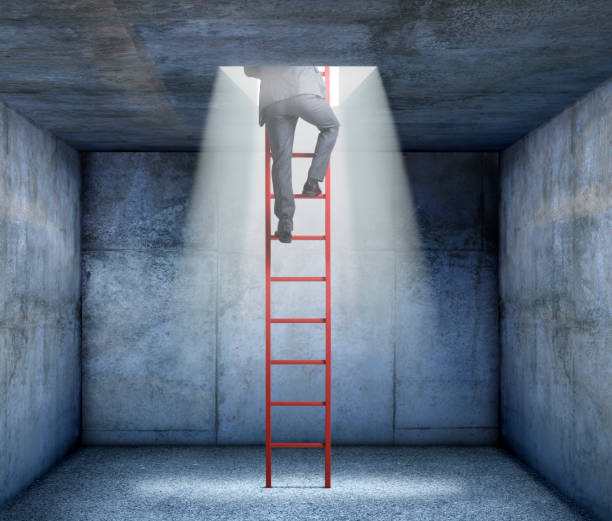 istock Businessman Uses Ladder To Exit Through Opening In Ceiling 858758970