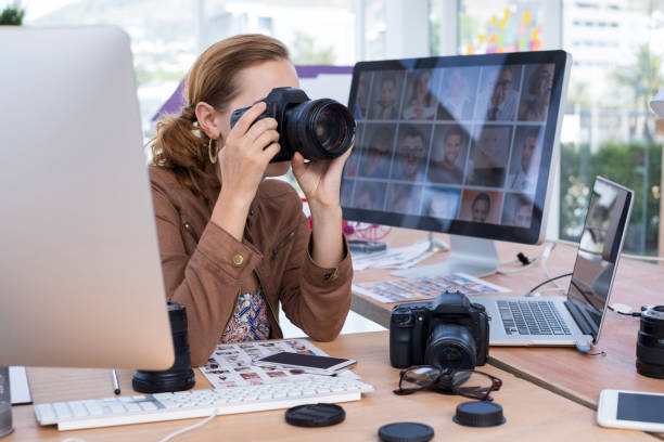 istock Female executive taking a photograph from digital camera 858763040