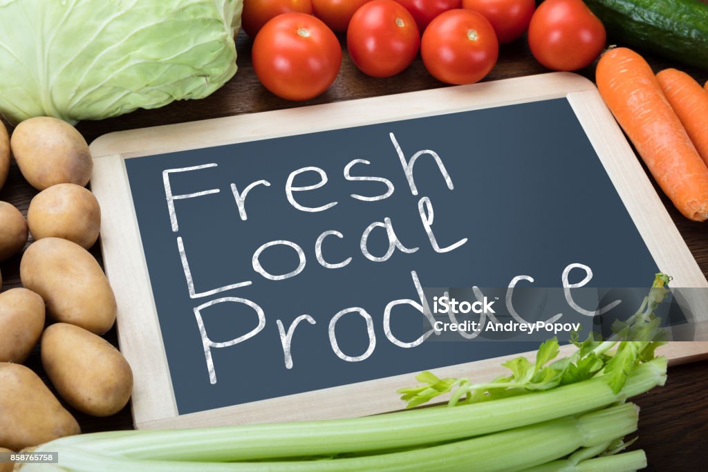Fresh Local Produce Written On Slate Fresh Local Produce Written On Slate With Various Vegetables On Table Above Stock Photo