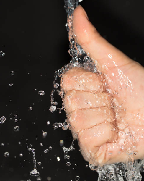 istock hand in water on a black background 858765776