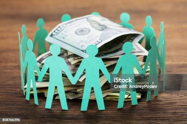 Cutout Figures Around The Hundred Dollar Bill Stock Photo - Download Image Now - Crowdfunding, Crowd of People, Investment