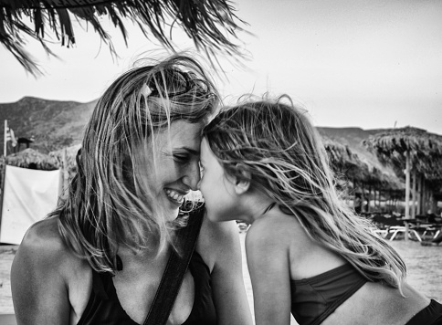 A Mother and Young Daughter Embrace on a Beach in the Greek Islands