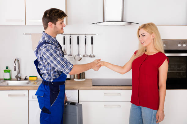 istock Repairman Shaking Hands With Woman In Kitchen 858766654