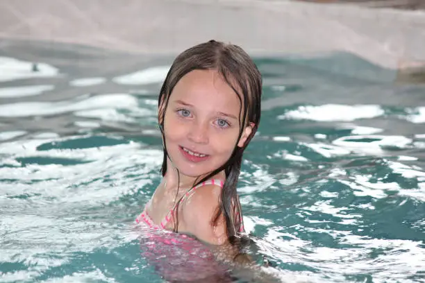 Young girl-child, playing in and, having fun in a swimming pool.