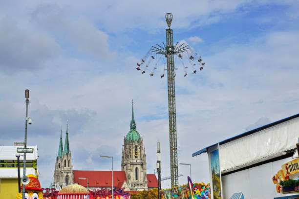 st. paul church and the jules-verne-tower carousel at the oktoberfest. munich, bavaria. - amusement park oktoberfest munich chain swing ride imagens e fotografias de stock