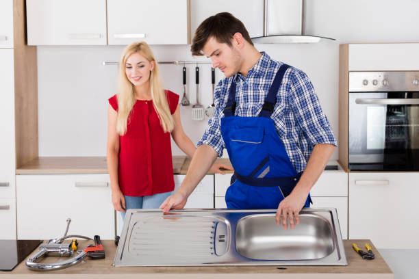 istock Male Plumber Fixing Stainless Steel Sink In Kitchen 858777310