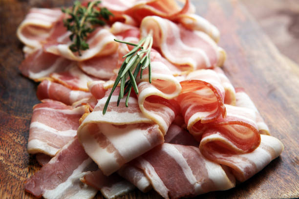 istock Raw sliced bacon with thyme leaves ready for cooking 858781228