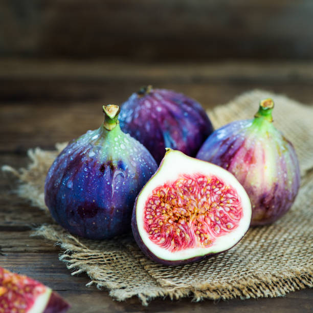 istock Ripe sweet figs on rustic wooden background. 858781240