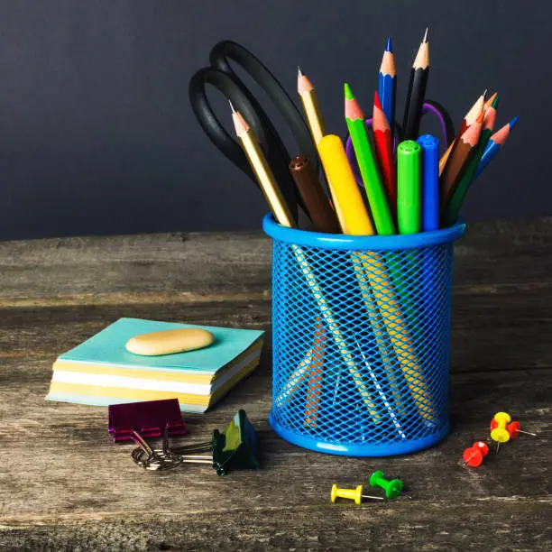 Pencil-box and school equipment on table. Back to school.