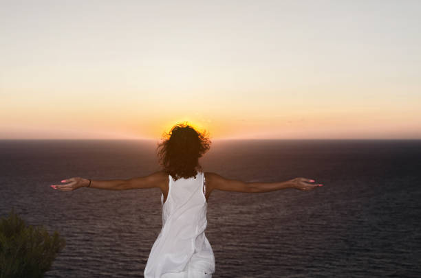 istock Woman with raised hands on sunset 858787346