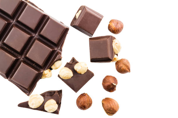 istock Pieces of bitter dark chocolate cubes with hazelnut isolated on white background, top view 858800968