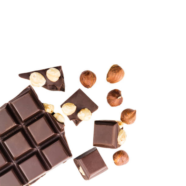 istock Pieces of bitter dark chocolate cubes with hazelnut isolated on white background, top view 858801004