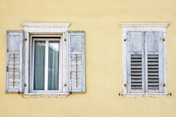 istock Two windows with window shutters in a yellow house 858801242