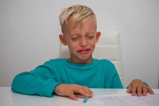 little boy crying doing homework