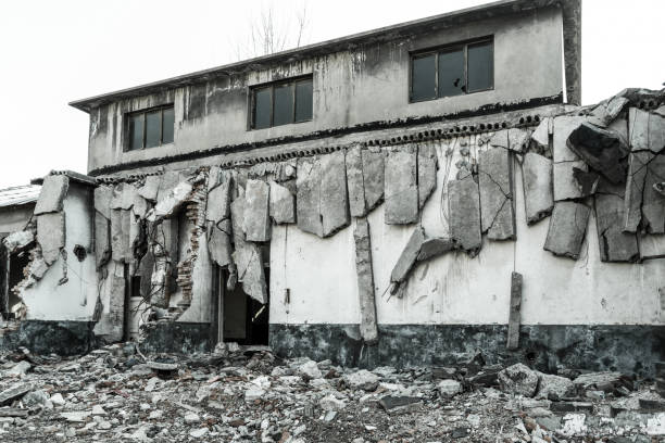 Interior of old factory buildings destroyed. Ruins of industrial enterprise, dark debris destroyed factory premises in factory as result of economic crisis and earthquake.