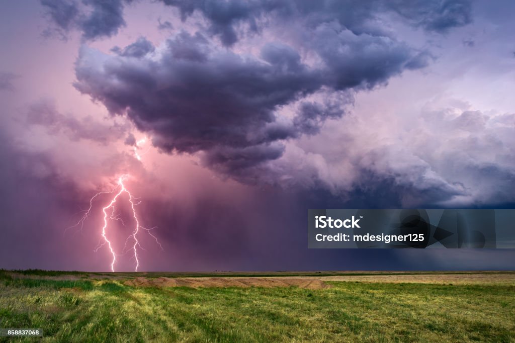 Thunderstorm with lightning bolts Thunderstorm with lightning bolts and dark, dramatic clouds over a field. Lightning Stock Photo