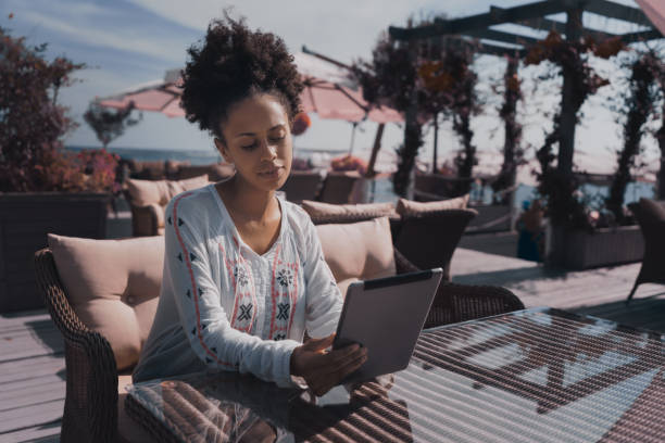 istock Ebony female with digital tablet in cafe outdoor 858848020